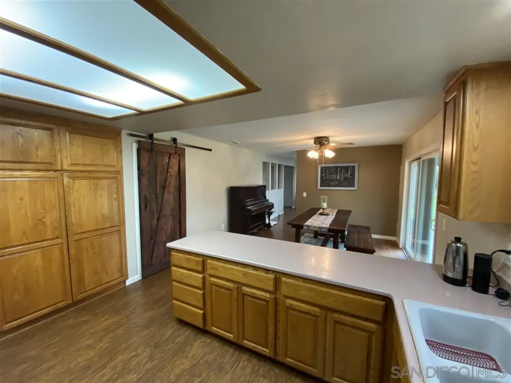 911 La Buena Vida Fallbrook, CA 92028 - Photo 5 of 24 a kitchen with stainless steel appliances granite countertop a sink refrigerator and microwave