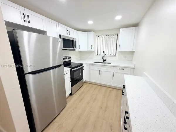 a kitchen with stainless steel appliances a refrigerator sink and microwave