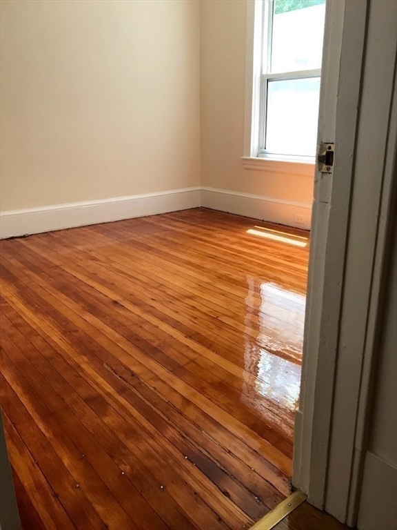 28 Beaconsfield Road, Unit 1 Brookline, MA 02445 - Photo 16 of 21 a view of empty room with wooden floor and fan