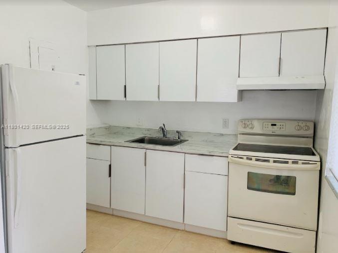 691 Northeast 86th Street, Unit 3 Miami, FL 33138 - Photo 2 of 10 a kitchen with white cabinets and white appliances