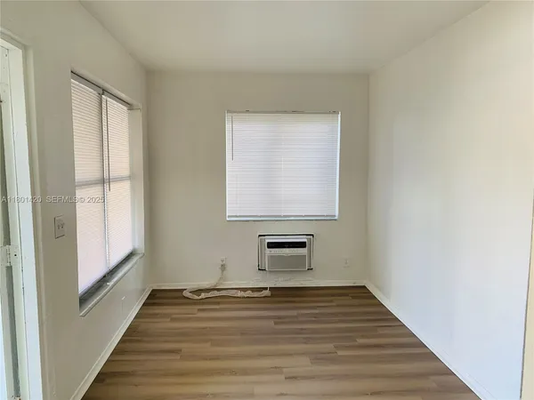 a view of a room with wooden floor and cabinet