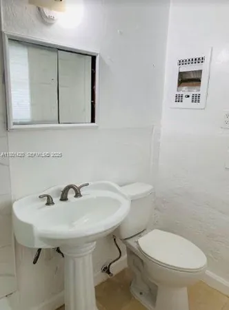 a bathroom with a sink a toilet and mirror