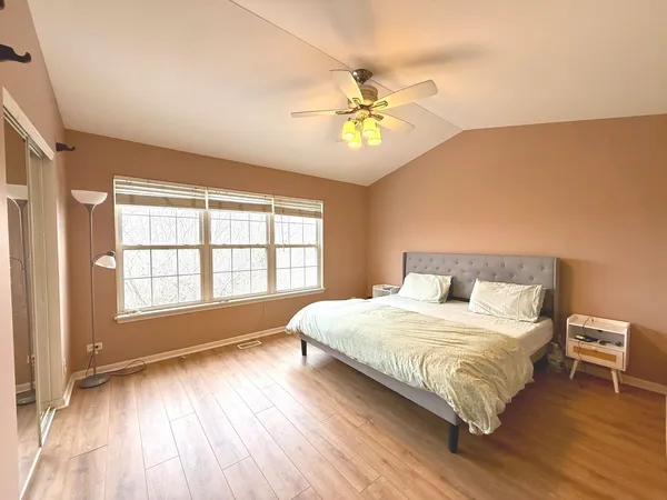 a bedroom with a large bed and a chandelier
