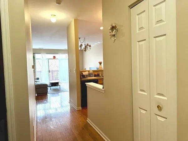 a view of a hallway with wooden floor windows and a bathroom