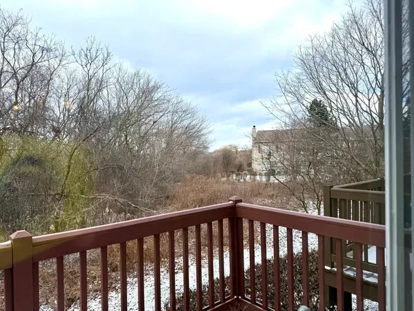 a view of a balcony with wooden floor and fence