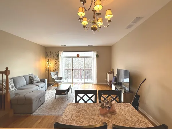 a living room with furniture a dining table and a chandelier