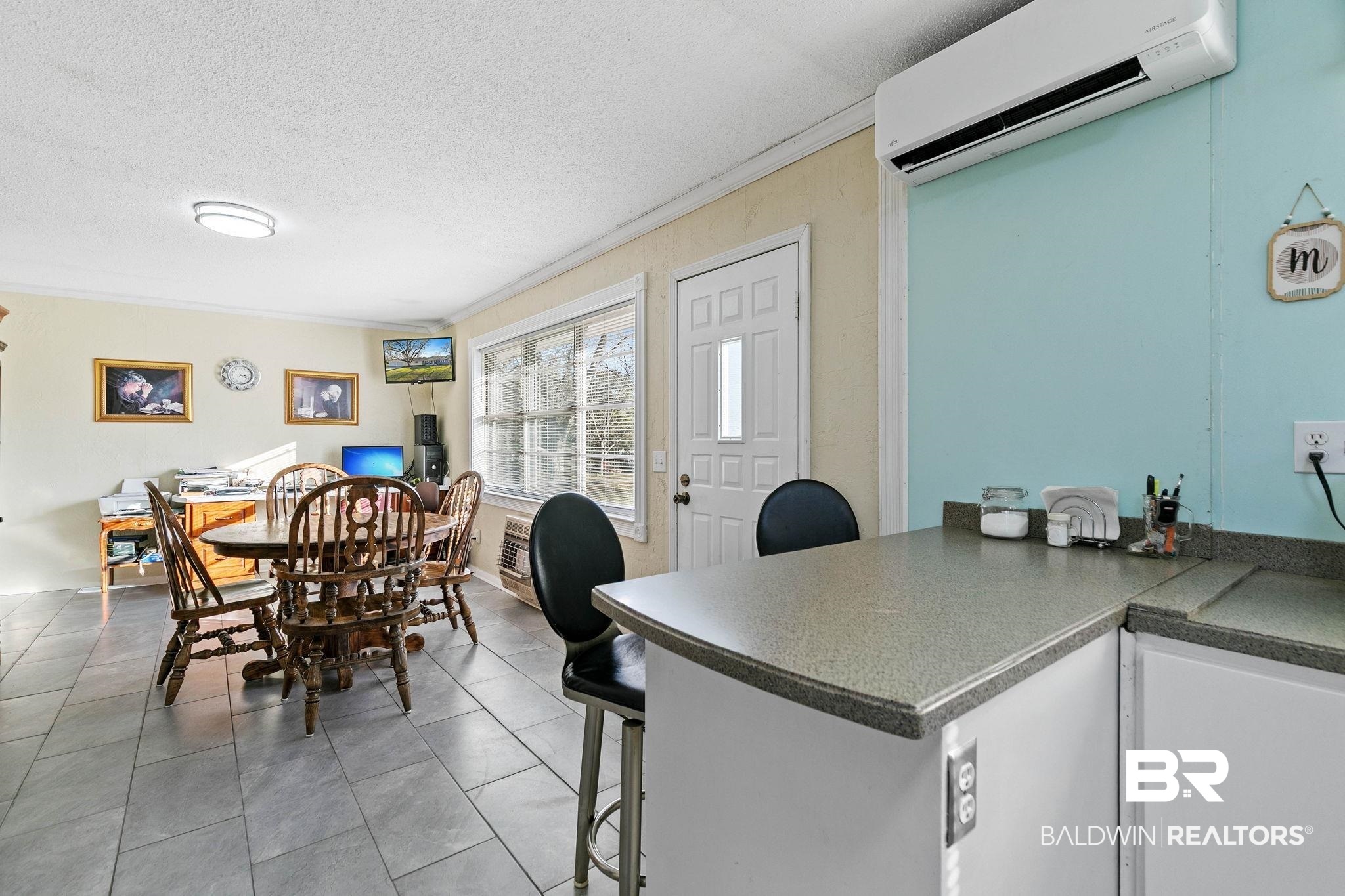 21267 Loop Road Andalusia, AL 36421 - Photo 26 of 72 Dining area with ornamental molding, a wall mounted air conditioner, dark tile patterned floors, and a textured ceiling