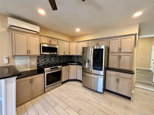 a kitchen with granite countertop a refrigerator and a stove top oven