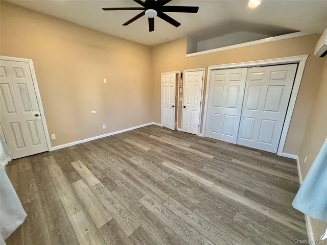 en empty room with wooden floor and fan