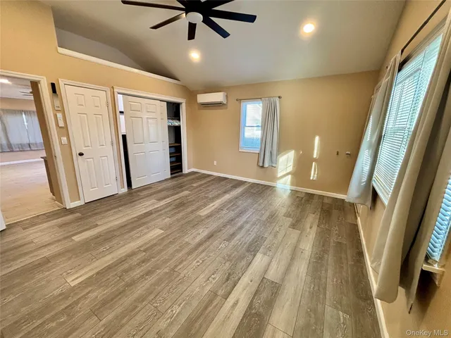 a view of a big room with wooden floor and windows