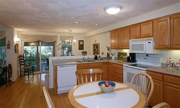 14 Deer Path, Unit 14 Hudson, MA 01749 - Photo 9 of 18 a kitchen with stainless steel appliances granite countertop a kitchen island hardwood floor sink stove dining table and chairs