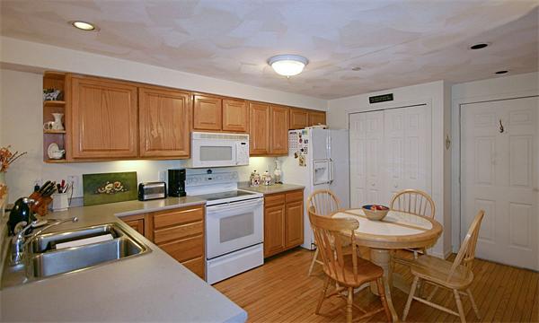 14 Deer Path, Unit 14 Hudson, MA 01749 - Photo 10 of 18 a kitchen with stainless steel appliances granite countertop a stove a sink dishwasher and a refrigerator with wooden cabinets