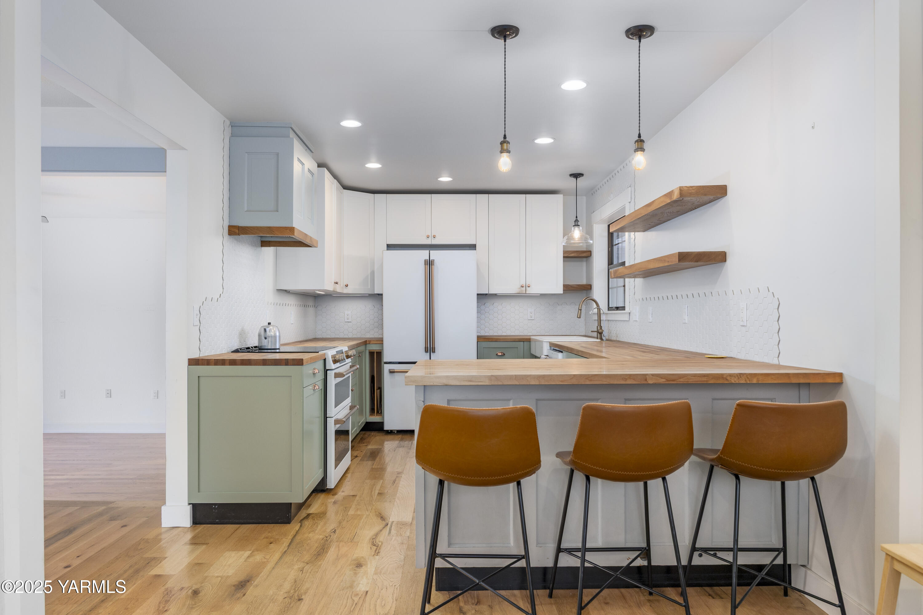 10240 Van Belle Road Sunnyside, WA 98944 - Photo 13 of 52 a kitchen with stainless steel appliances granite countertop a sink a stove a refrigerator and white cabinets with wooden floor