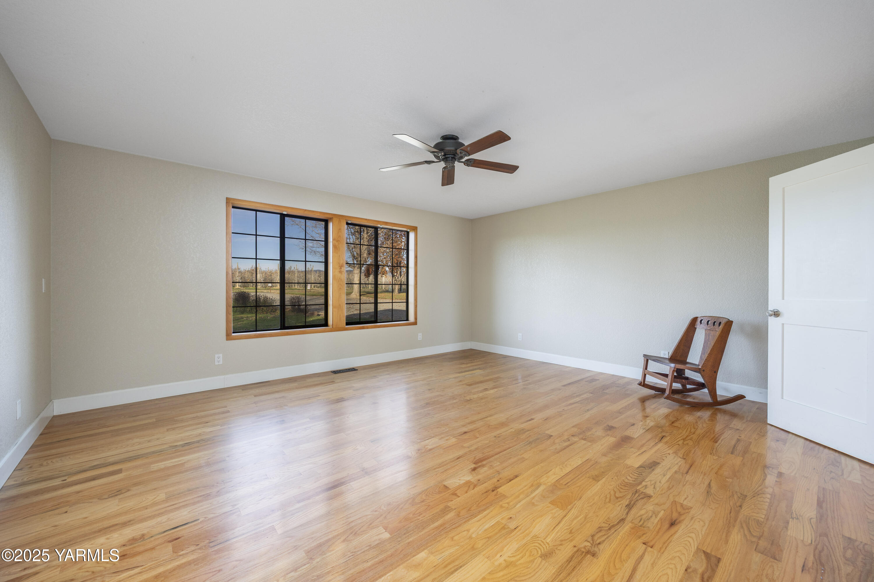 10240 Van Belle Road Sunnyside, WA 98944 - Photo 31 of 52 a view of room with wooden floor and a ceiling fan