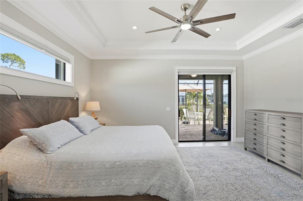 7416 South Seagrape Road Punta Gorda, FL 33955 - Photo 15 of 39 a bedroom with a large bed and a chandelier fan