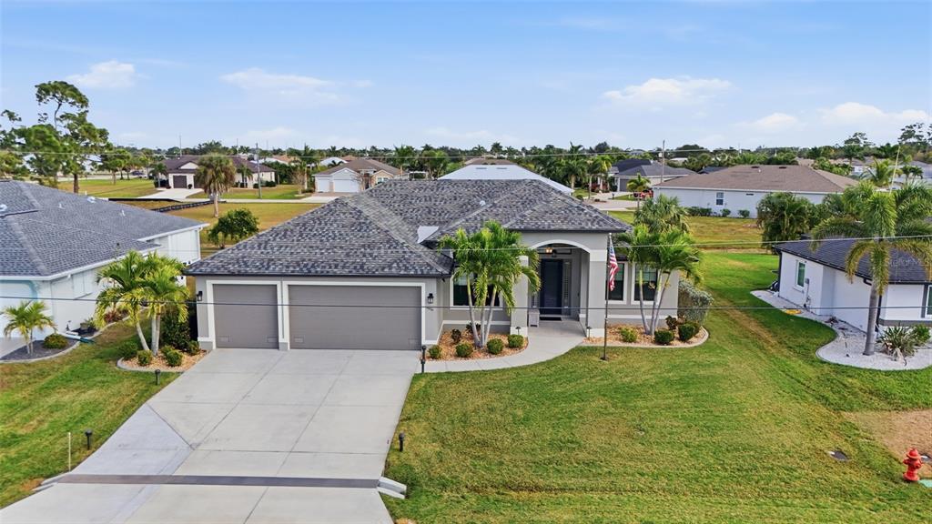 7416 South Seagrape Road Punta Gorda, FL 33955 - Photo 2 of 39 a front view of a house with a garden and lake view