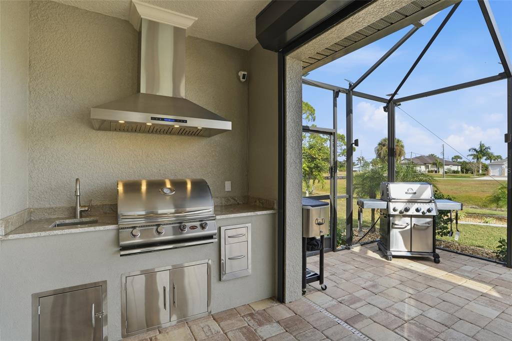 7416 South Seagrape Road Punta Gorda, FL 33955 - Photo 28 of 39 a kitchen with stainless steel appliances granite countertop a stove a sink and a microwave
