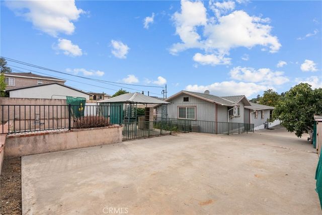 a front view of a house with a yard and potted plants