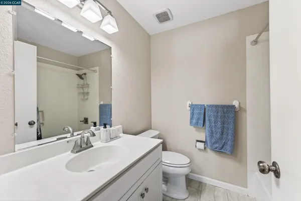 a bathroom with a sink vanity granite and toilet