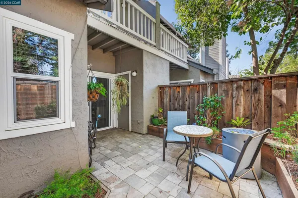 a view of a chair and table in backyard of the house