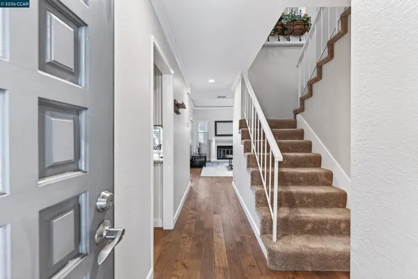a view of staircase with lots of frames on wall and a window