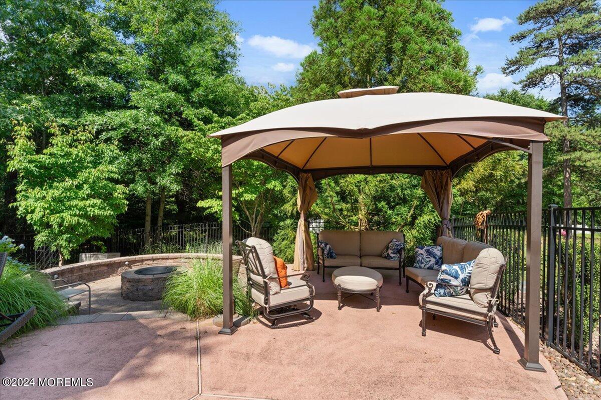 26 Emily Road Manalapan, NJ 07726 - Photo 41 of 49 a view of a patio with a table and chairs under an umbrella