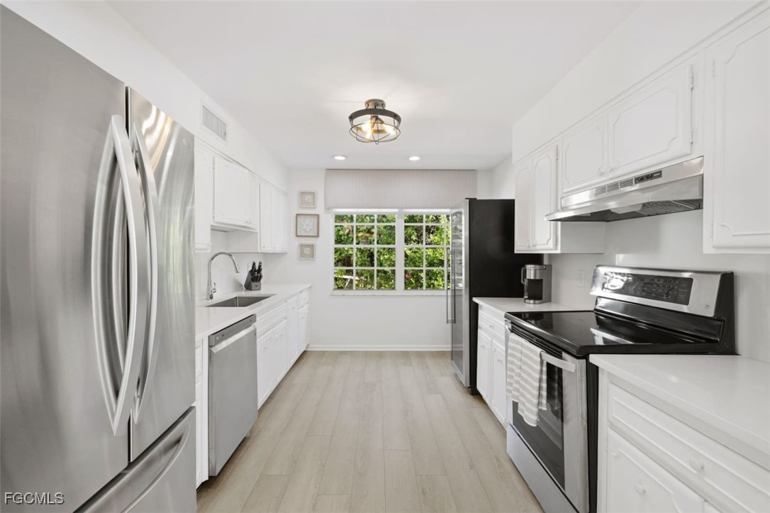 2728 Crayton Road Naples, FL 34103 - Photo 11 of 35 a kitchen with a refrigerator a sink and a stove