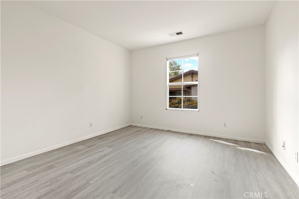 8541 Oak Barrel Place, Unit 2 Rancho Cucamonga, CA 91730 - Photo 14 of 50 an empty room with wooden floor and windows