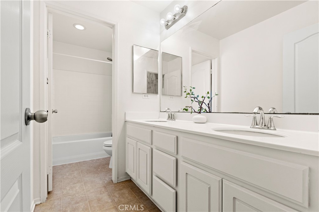 8541 Oak Barrel Place, Unit 2 Rancho Cucamonga, CA 91730 - Photo 16 of 50 a bathroom with a double vanity sink a toilet and a mirror