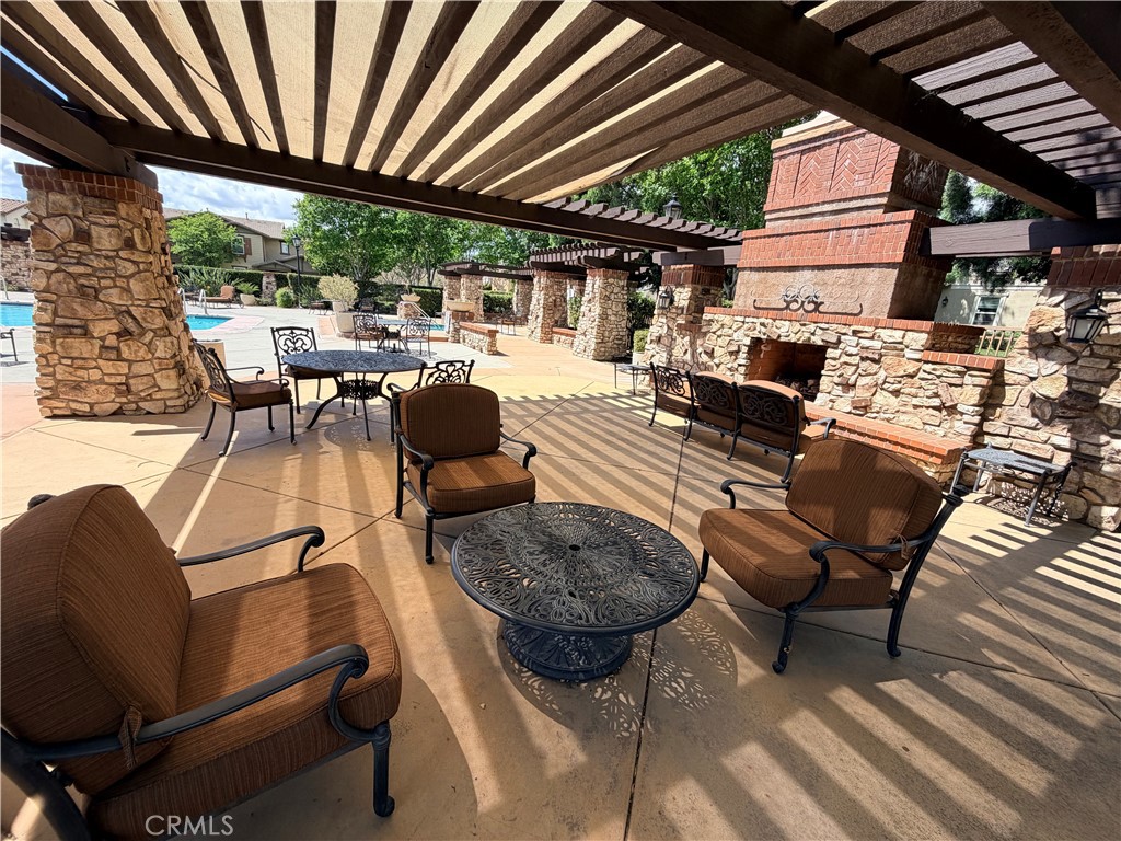 8541 Oak Barrel Place, Unit 2 Rancho Cucamonga, CA 91730 - Photo 35 of 50 a view of a patio with table and chairs barbeque potted plants and large tree