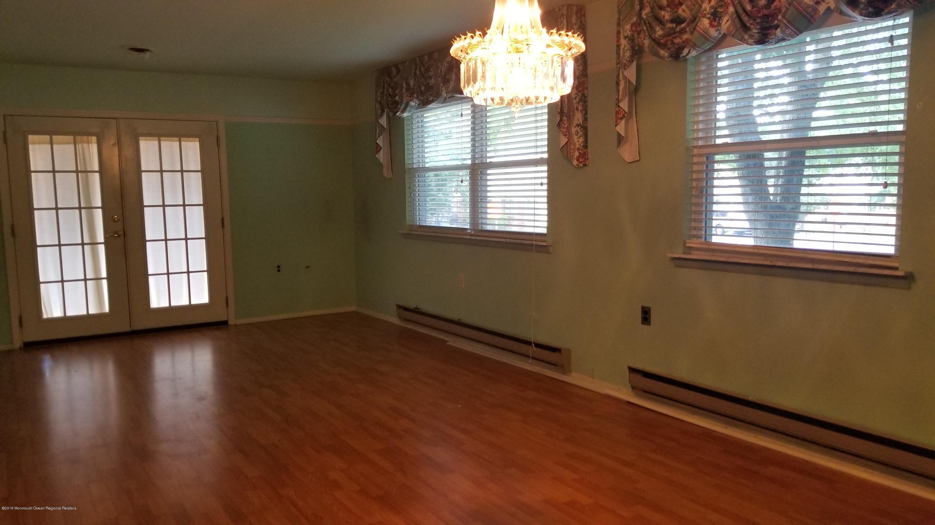 2 Conestoga Drive, Unit A Whiting, NJ 08759 - Photo 5 of 12 a view of an empty room with wooden floor and a window