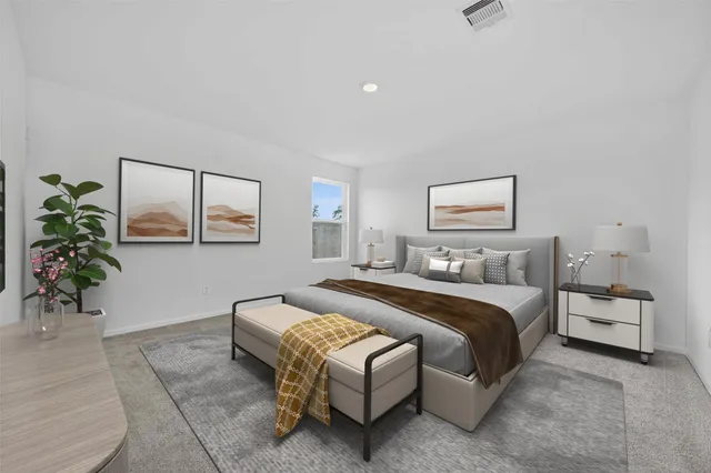 a bedroom with a bed lamp and paintings on the wall