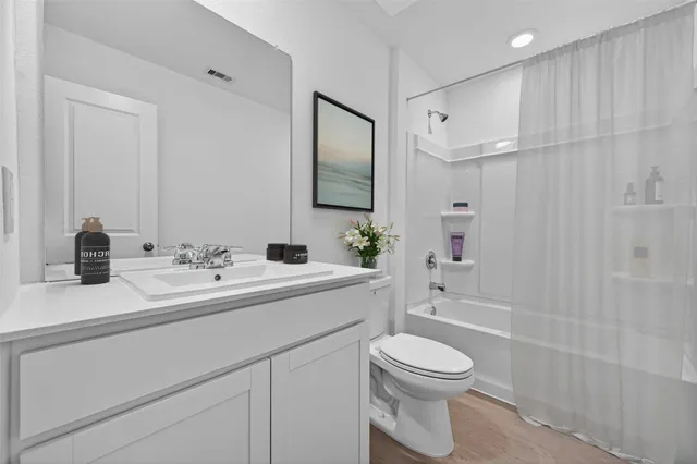 a bathroom with a toilet a sink a mirror and shower