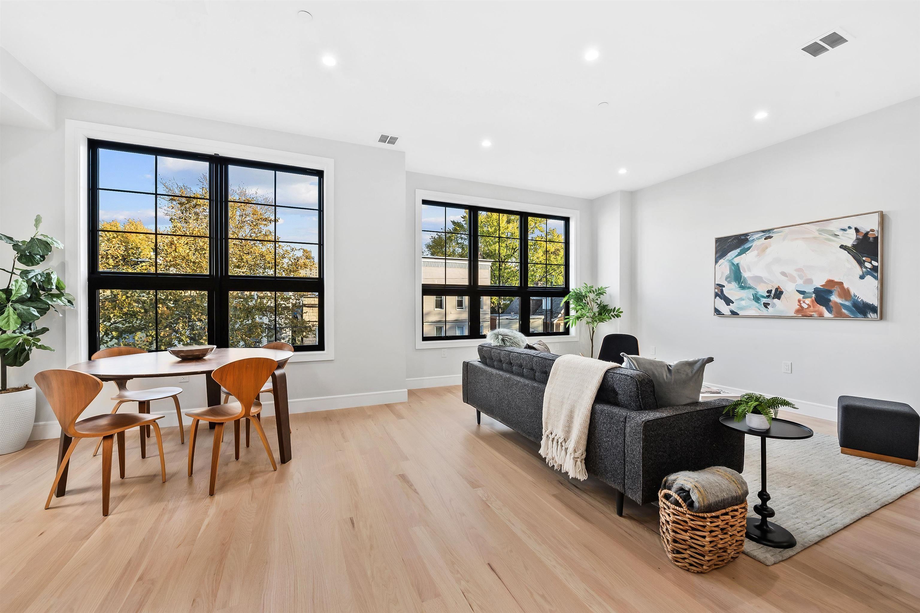a living room with furniture a wooden floor and next to a window