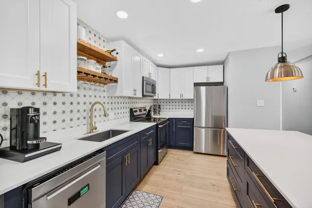 a kitchen with stainless steel appliances a sink stove and refrigerator