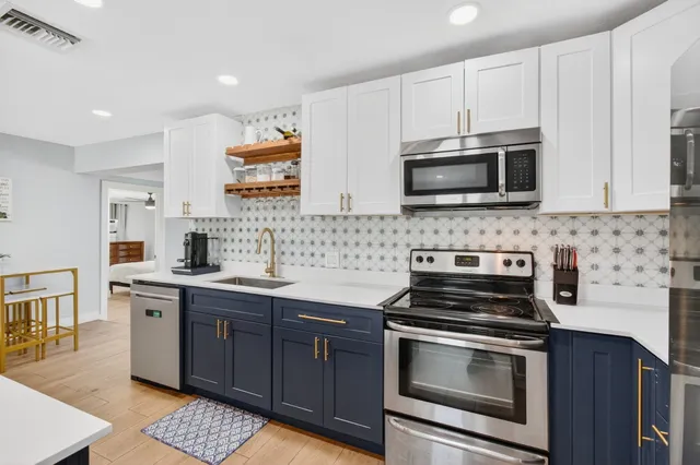 a kitchen with stainless steel appliances a stove microwave and sink