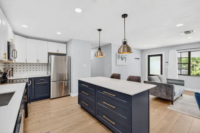 a room with kitchen island granite countertop stainless steel appliances lots of counter top space