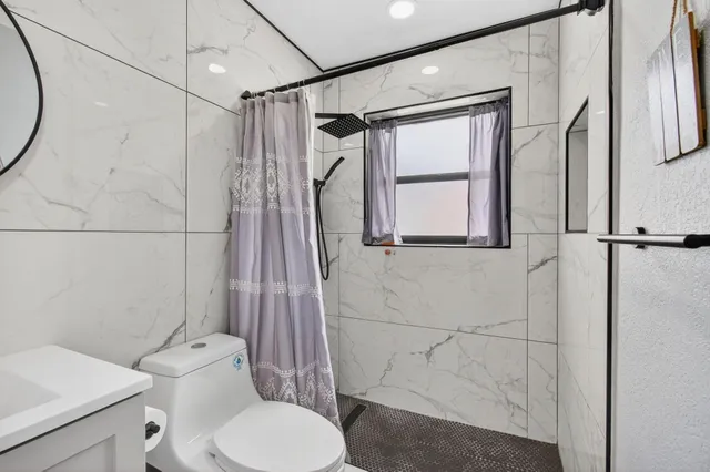 a white toilet sitting next to a shower curtain