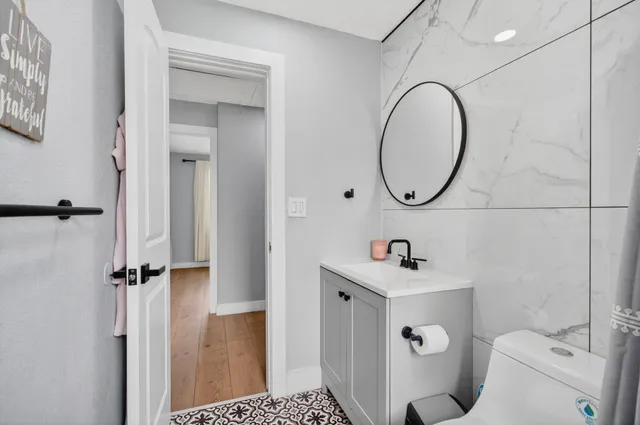 a bathroom with a sink toilet and a mirror