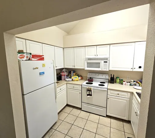 a white refrigerator freezer and a stove sitting inside of a kitchen