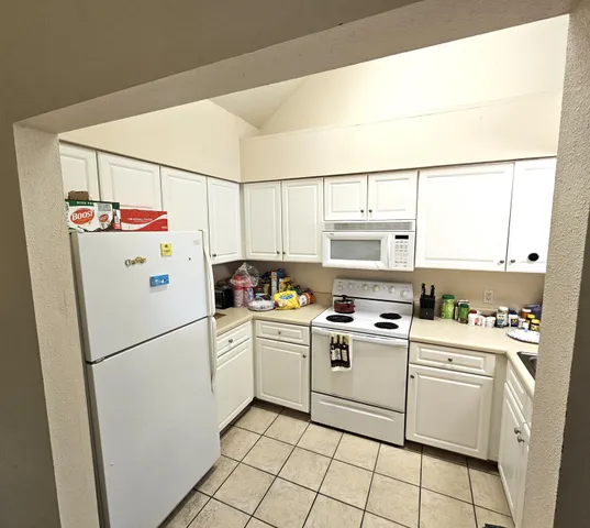 a white refrigerator freezer and a stove sitting inside of a kitchen