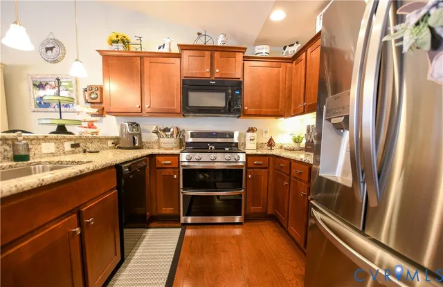 a kitchen with stainless steel appliances a refrigerator sink and stove