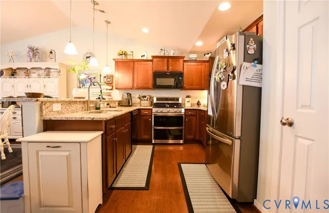 a kitchen with stainless steel appliances a stove a sink and a refrigerator