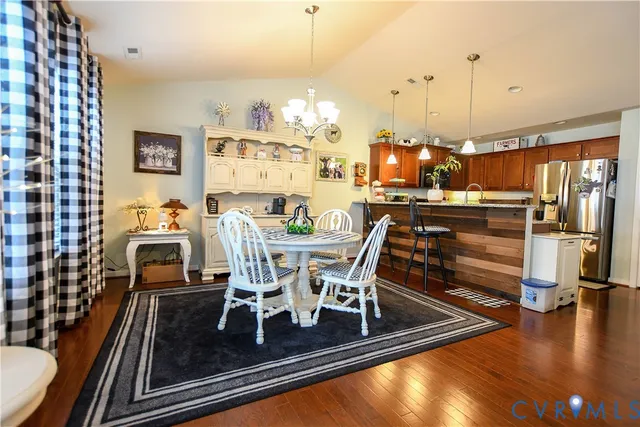 a view of a dining room with furniture a chandelier and wooden floor