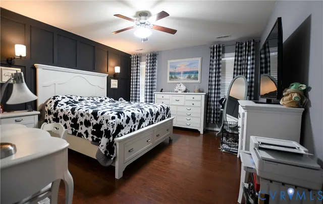 a bedroom with bed and a flat tv screen on dresser