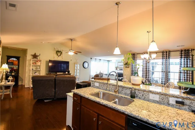 a living room with furniture a flat screen tv and kitchen view