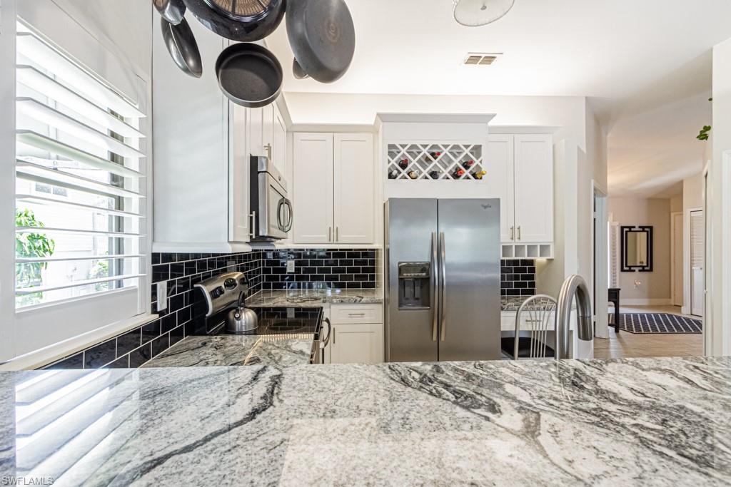410 Panay Avenue Naples, FL 34113 - Photo 12 of 34 a kitchen with a refrigerator and a sink