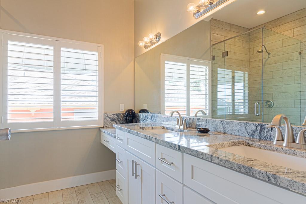 410 Panay Avenue Naples, FL 34113 - Photo 18 of 34 a bathroom with a granite countertop sink and a window