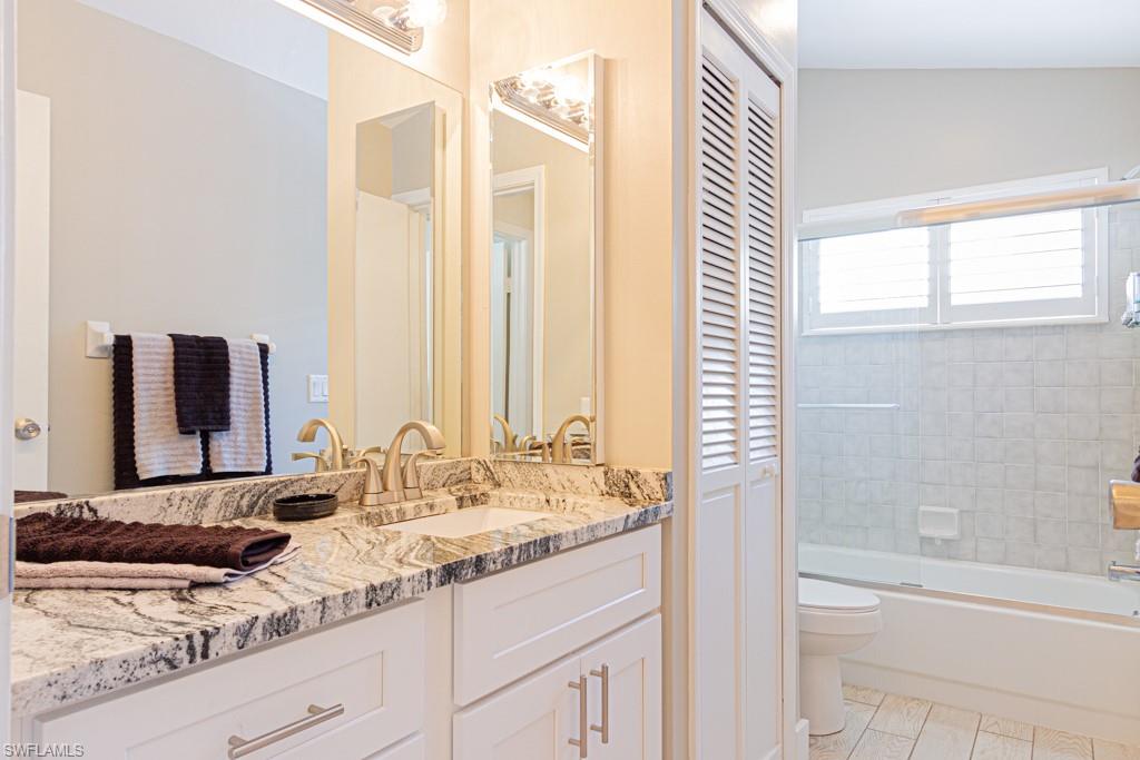 410 Panay Avenue Naples, FL 34113 - Photo 20 of 34 a bathroom with a granite countertop sink and a mirror