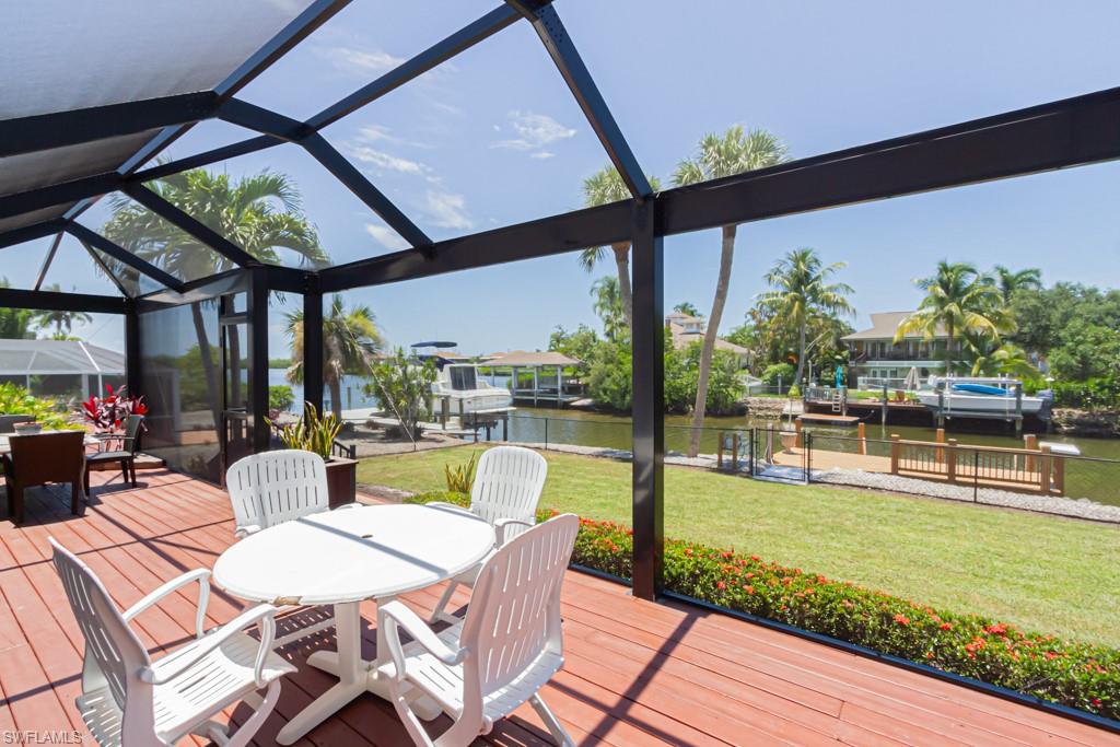 410 Panay Avenue Naples, FL 34113 - Photo 28 of 34 a view of a patio with couches chairs dining table and chairs with wooden floor